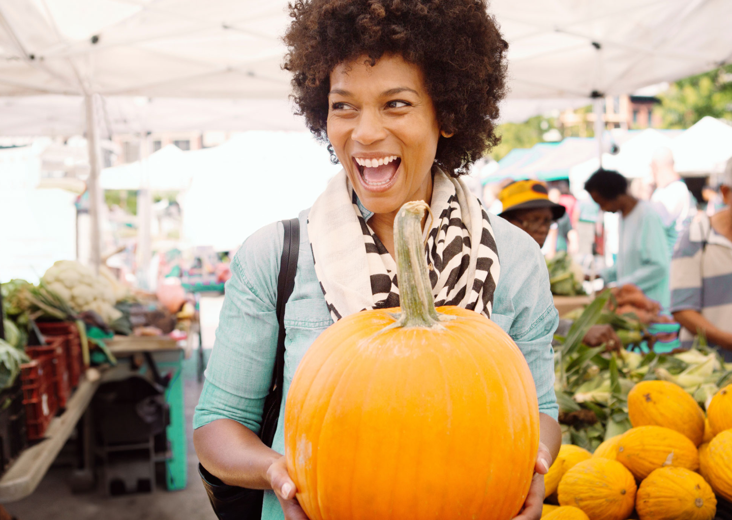 A smiling woman holding a pumpkin